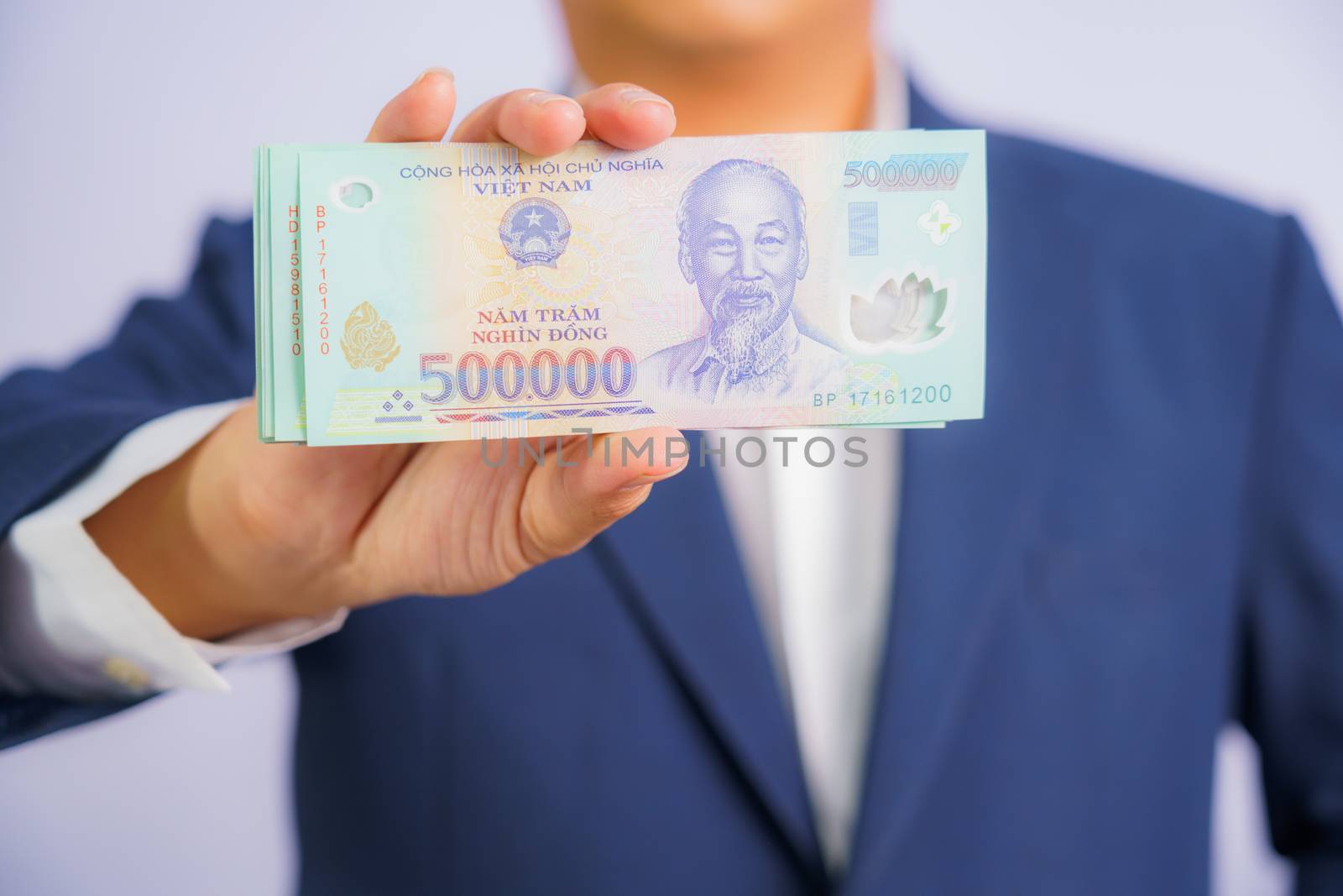 Money in Vietnam hold on hand business man wearing a blue suit (Socialist Republic Of Vietnam), Dong, VND, Pay, exchange money vietnamese on white background.