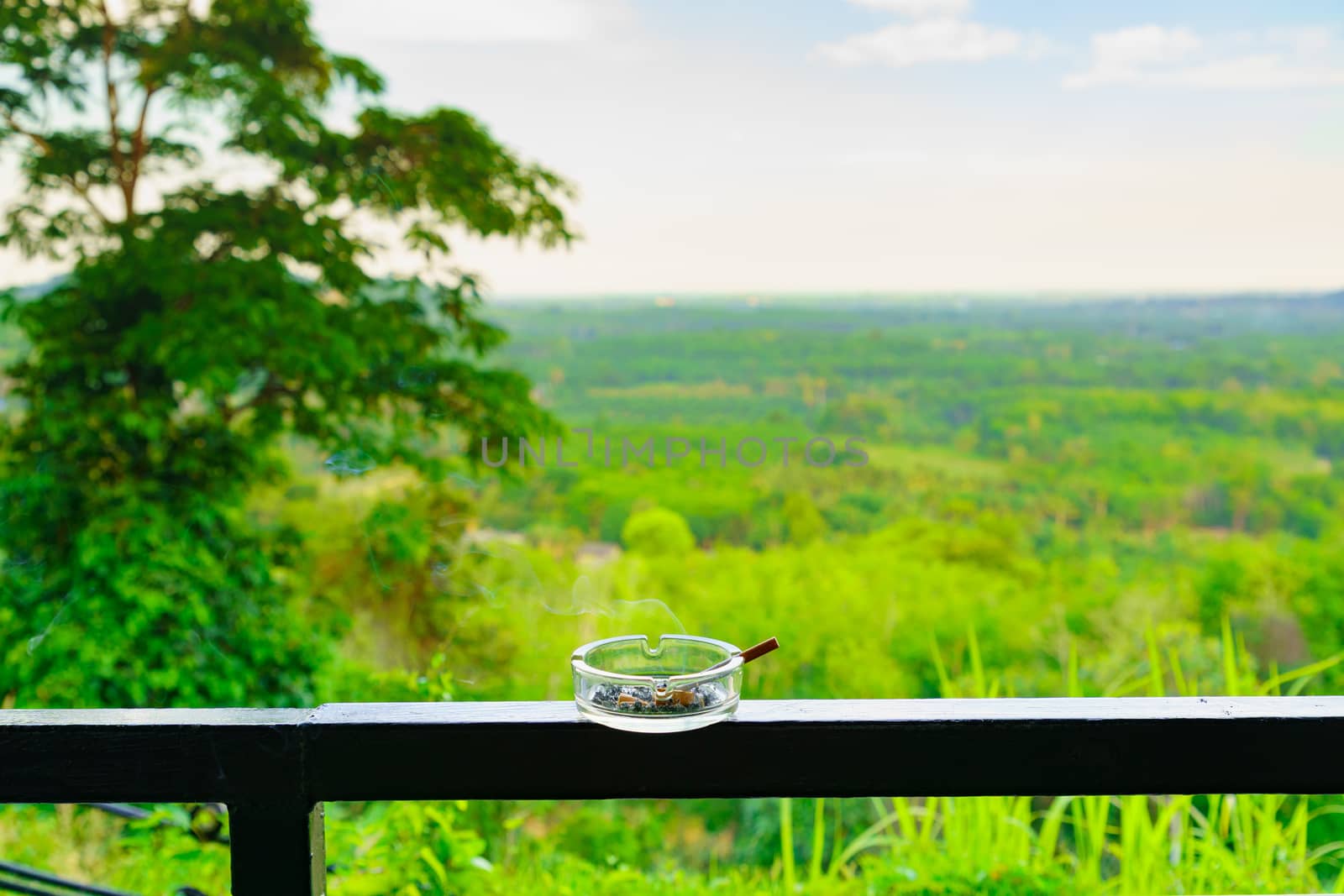 Smoking cigarette is not good for health in ashtray on the balco by bbbirdz