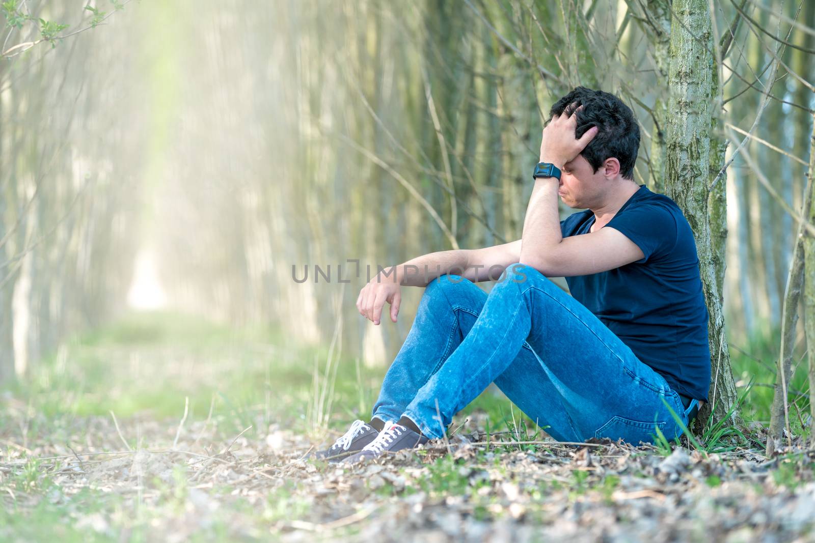 Unhappy man in the forest suffers from depression and frustration of life. copy space by Edophoto