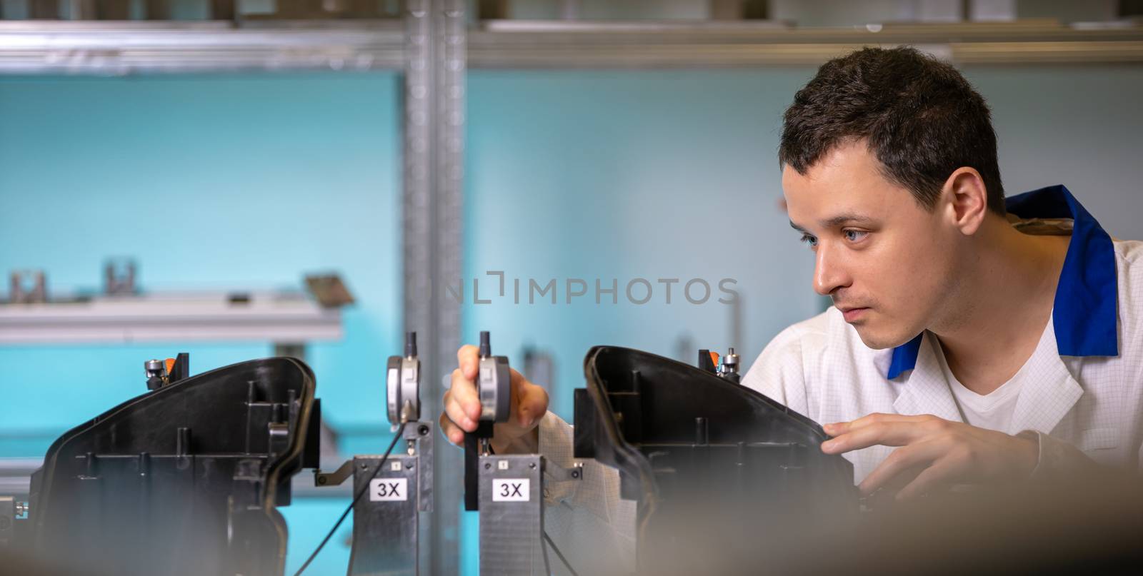 Automotive. Quality Engineer performs measurement of plastic casting for future light by Edophoto