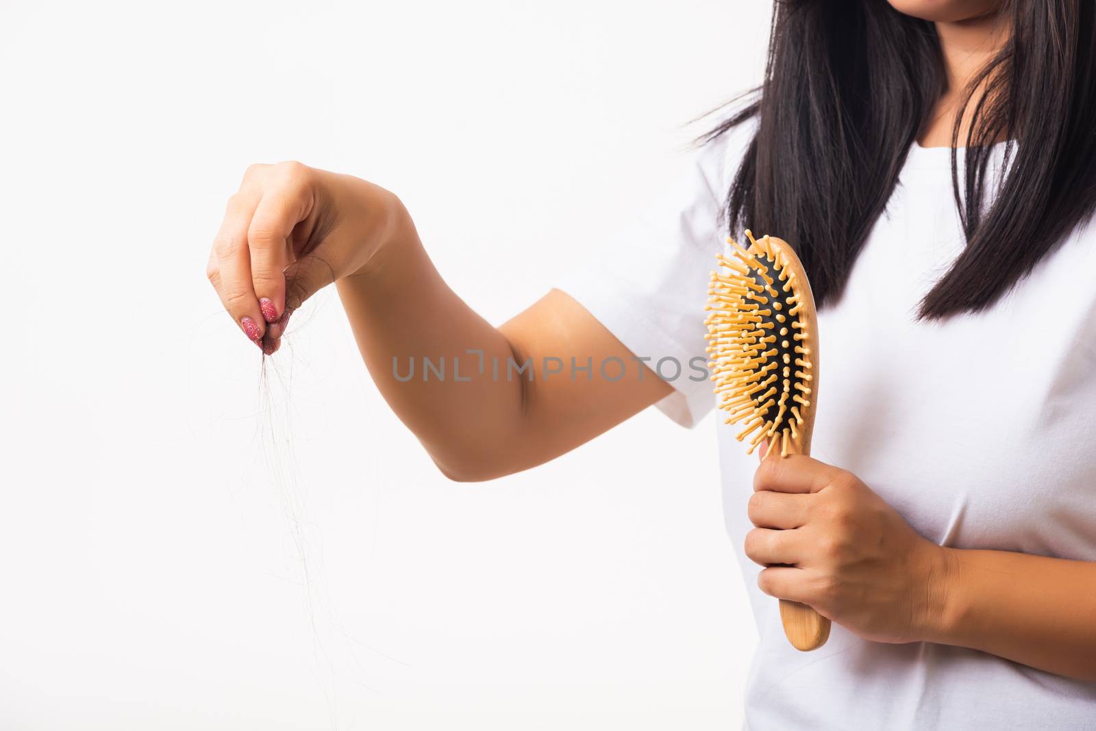 Asian woman unhappy weak hair problem her hold hairbrush with damaged long loss hair in the comb brush she pulls loss hair from the brush, isolated on white background, Medicine health care concept
