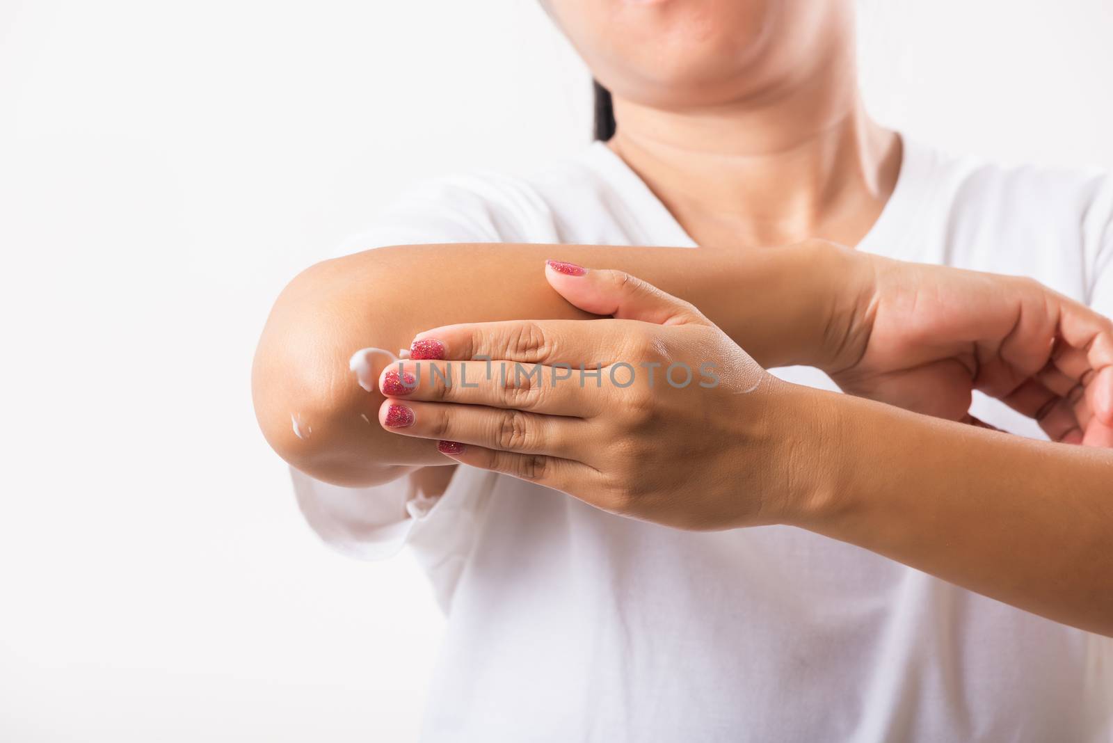 Woman applies lotion cream on her elbow by Sorapop