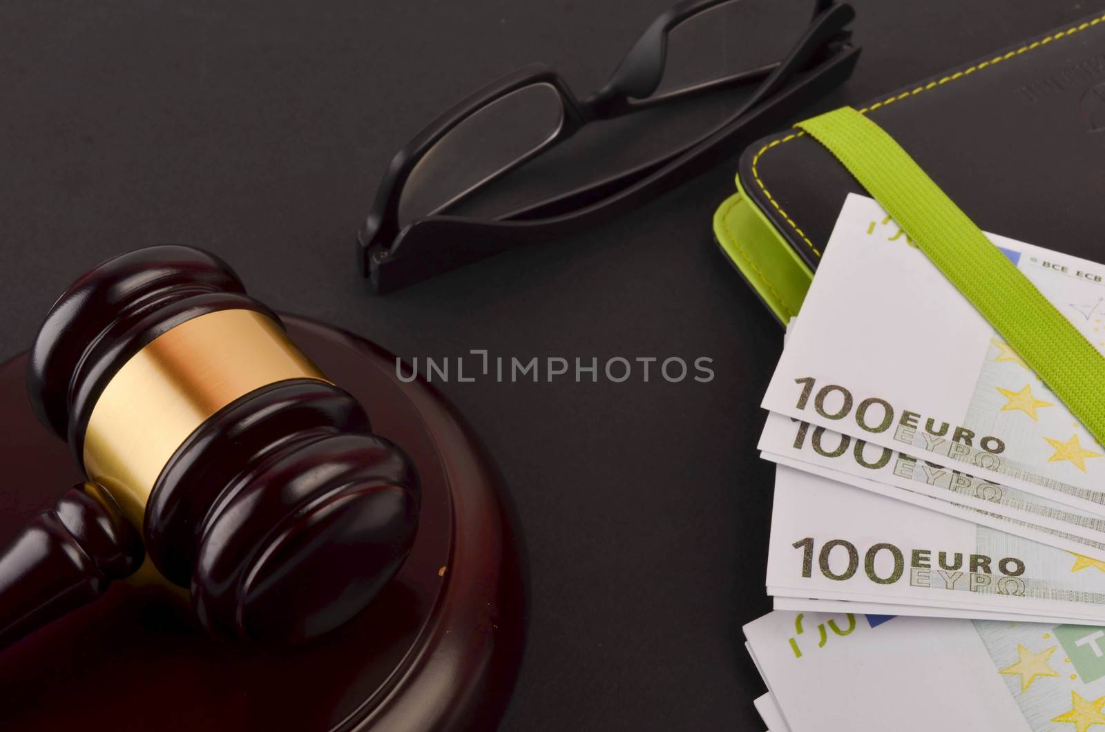 Gavel for judge lawyer with Euro banknotes on black background.