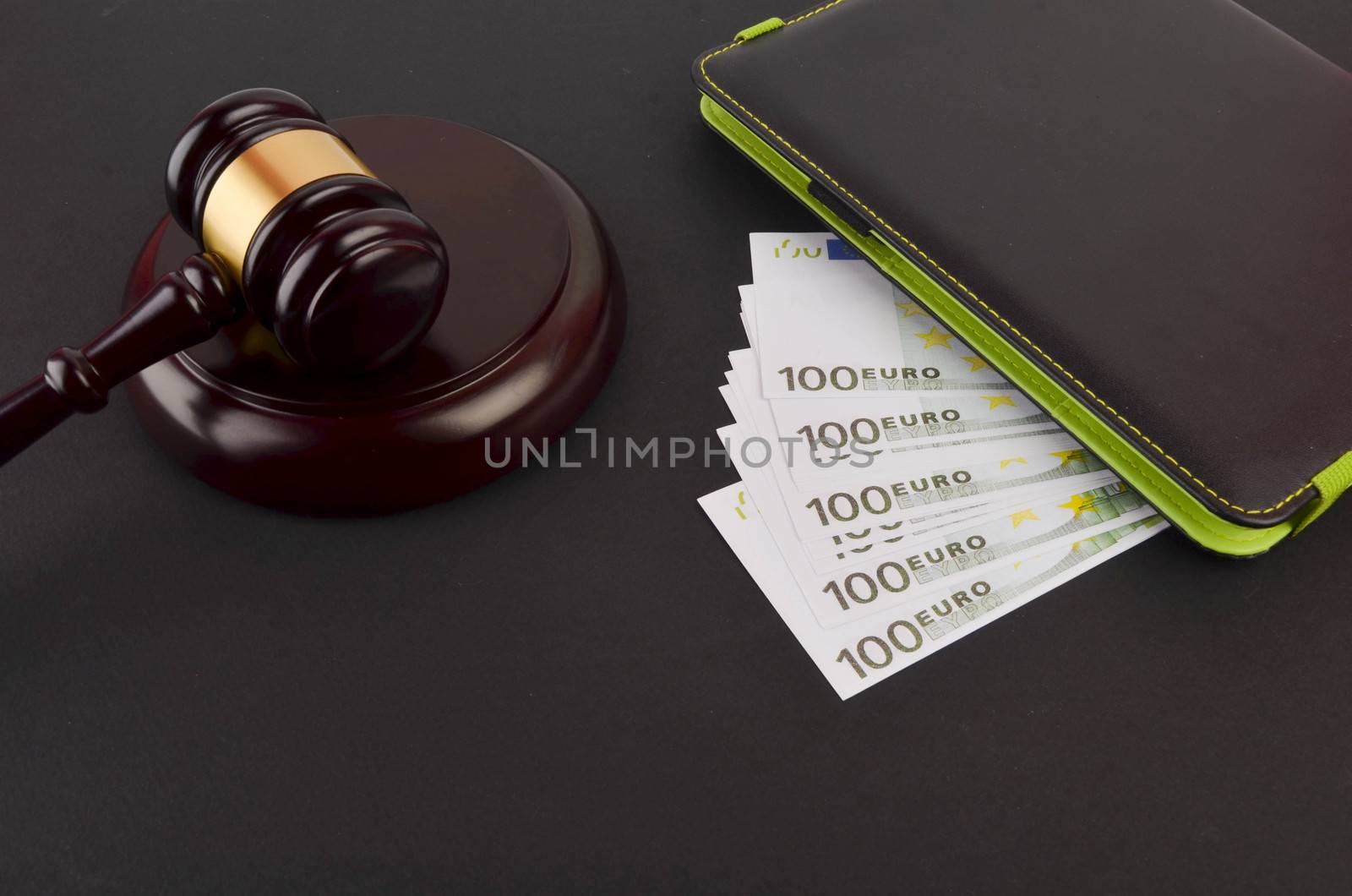 Gavel for judge lawyer with Euro banknotes on black background.