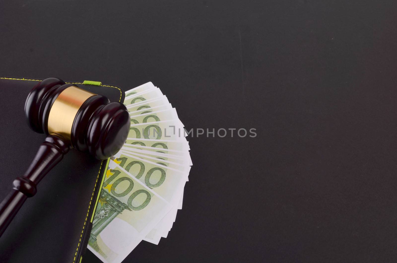 Gavel for judge lawyer with Euro banknotes on black background.