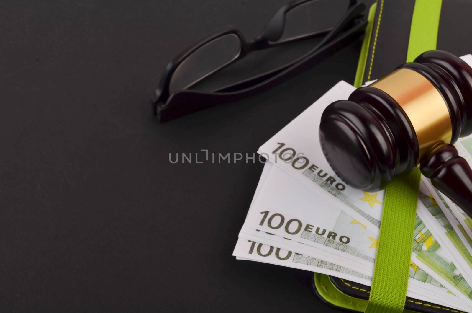 Gavel for judge lawyer with Euro banknotes on black background.