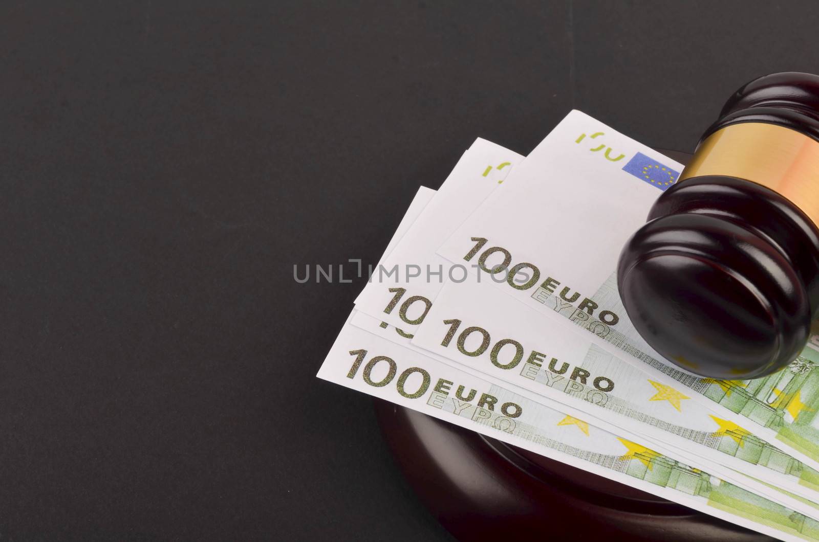 Gavel for judge lawyer with Euro banknotes on black background.
