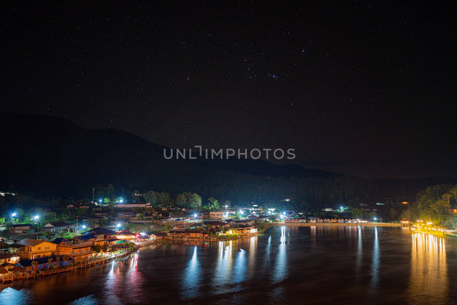 Landscape night view and Constellations of stars at night a small village in the middle of the mountains With a large river and the city in Ban Rak Thai, Mae Hong Son, THAILAND