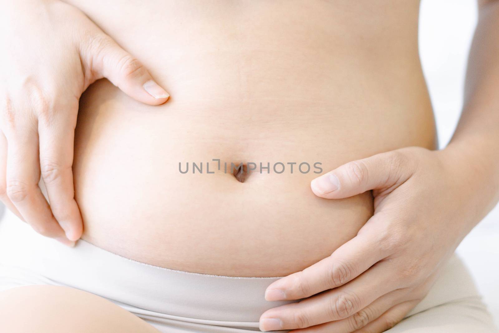 Pregnancy woman on white bed background, health care and medical concept,Young woman expecting a baby