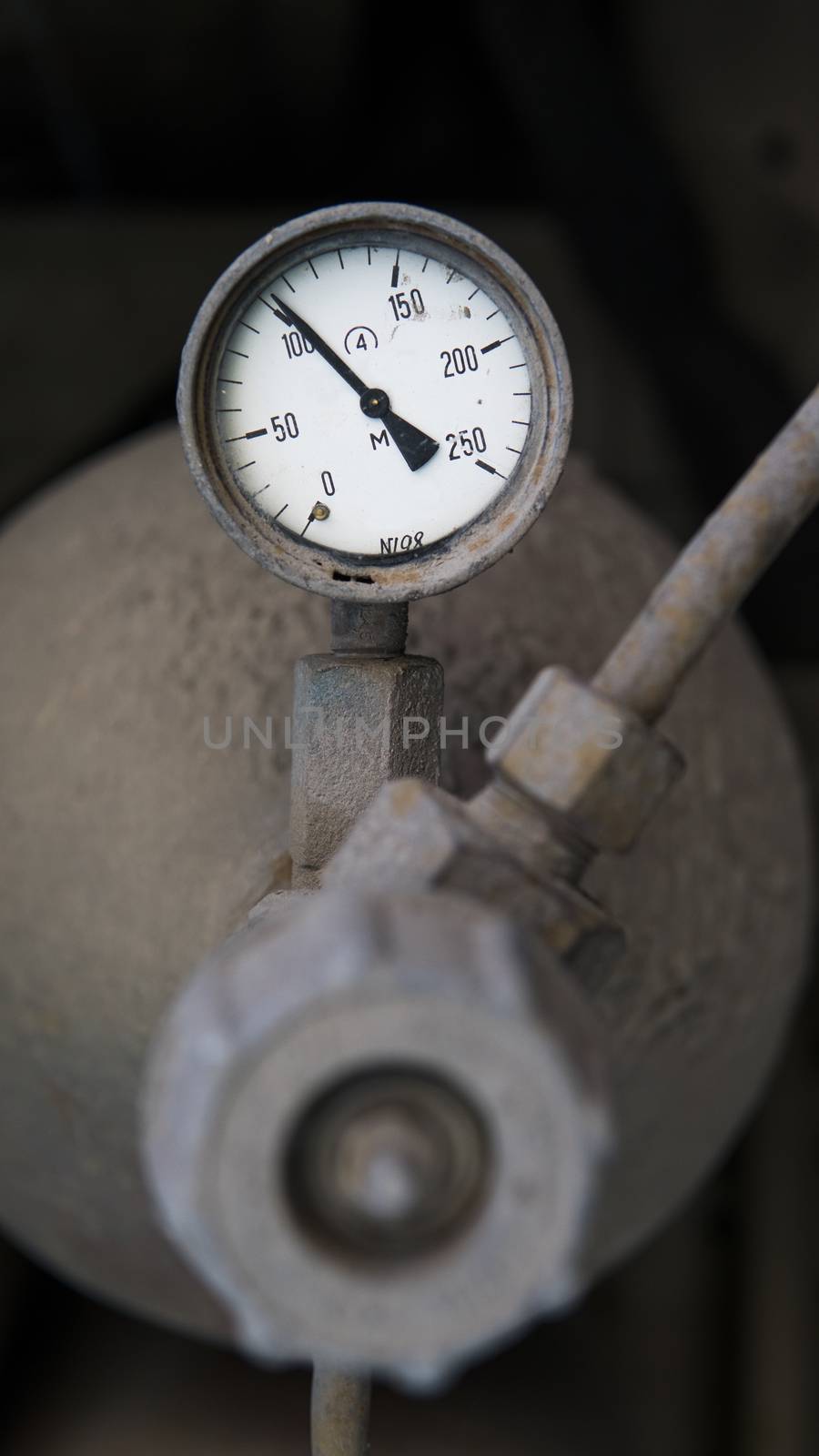 Industrial old white vintage barometer with old dirty gas cylinder