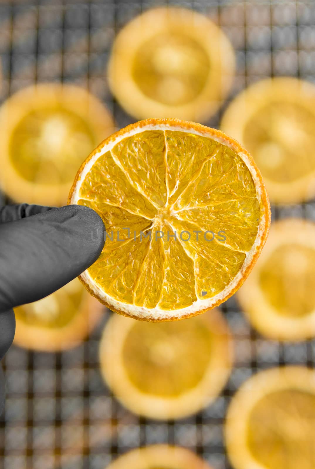 Candied orange slices on grid for drying. Dried fruits which can be used as a decoration to the meal or cocktails. Healthy vegetarian food rich on a vitamins and microelements