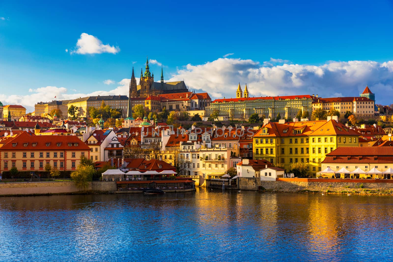 Prague Castle, Charles Bridge and boats on the Vltava river. View of Hradcany Prague Castle, Charles Bridge and a boats on the Vltava river in the capital of the Czechia. Boat cruise on Vltava river.