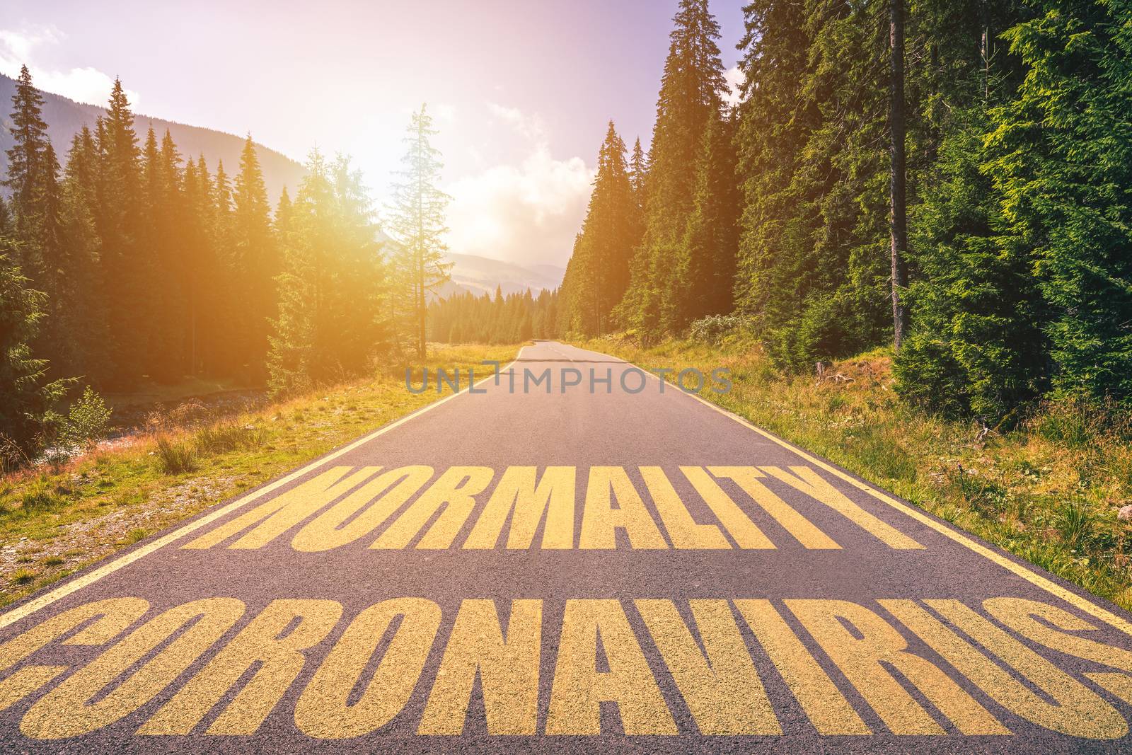 Driving on the road in the mountains to the New Normal (Normality) and leaving behind Covid-19 (Coronavirus). Covid-19 (Coronavirus) written on the asphalt road and New Normal or Normality concept. 