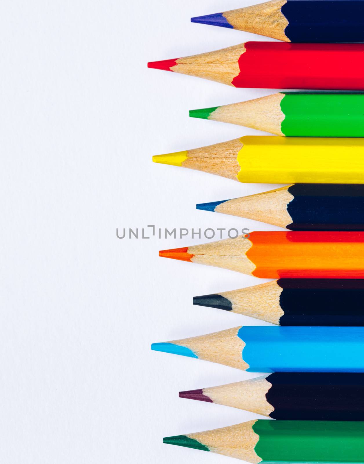 Color pencils isolated on white background. Close up of colored rainbow pencils for drawing, concept of preparing for school and discounts on stationery before the school year.