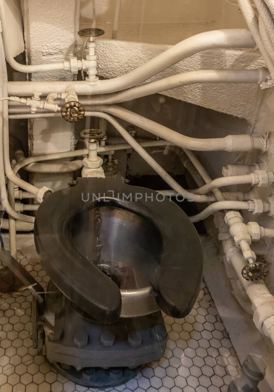 Oahu, Hawaii, USA. - January 10, 2020: Pearl Harbor. Black toilet bowl with white painted pipes and tubes in back in long submarine USS Bowfin.