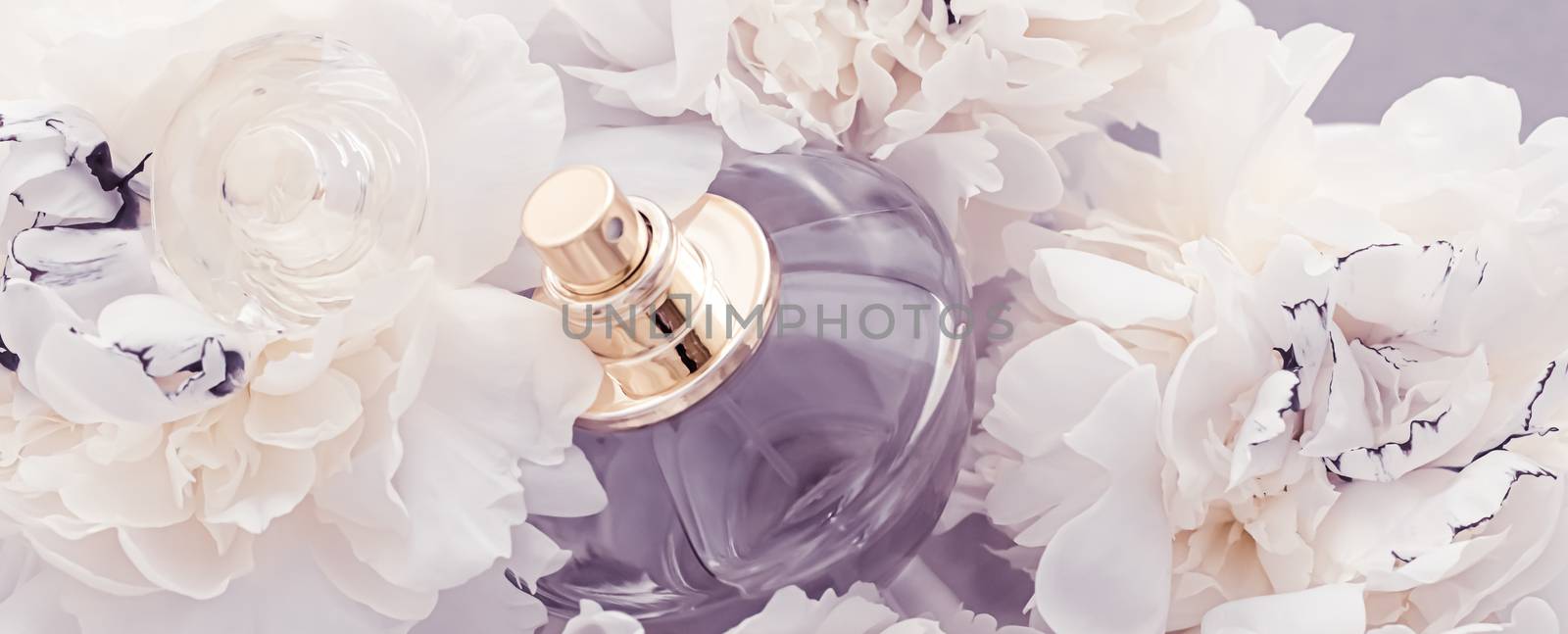 Violet fragrance bottle as luxury perfume product on background of peony flowers, parfum ad and beauty branding design