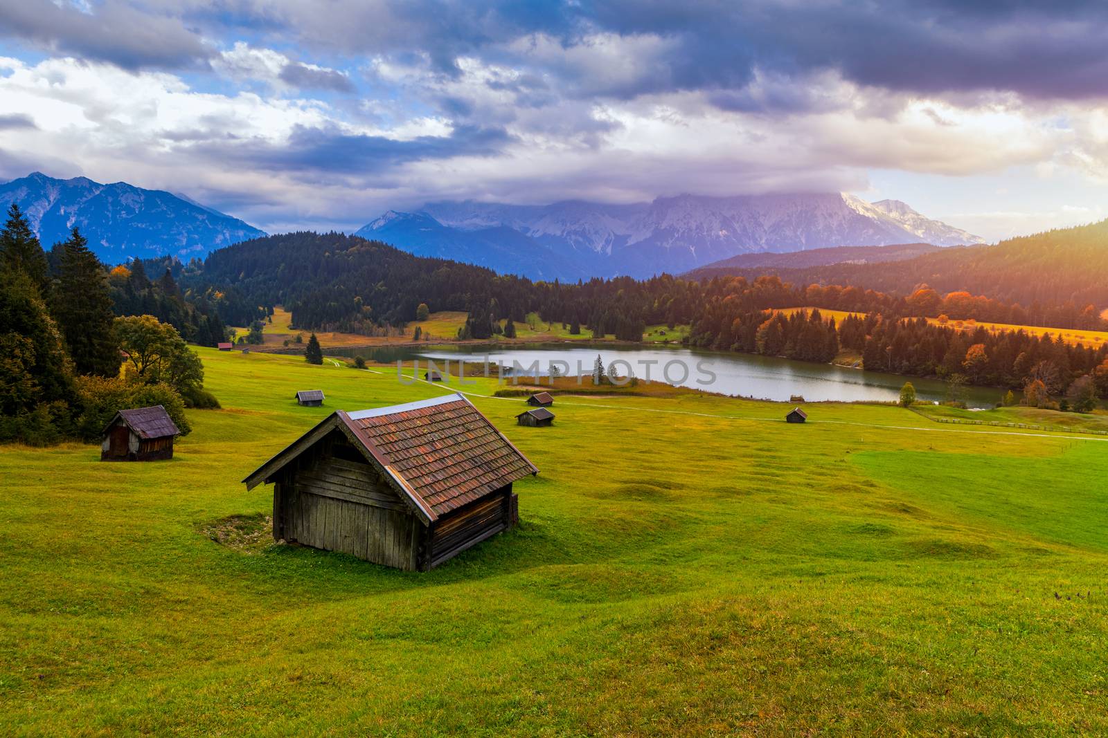 Panoramic morning scene of Wagenbruchsee (Geroldsee) lake with Zugspitze mountain range on background. Amazing autumn view of Bavarian Alps, Germany, Europe. Wooden hut on meadow by Geroldsee lake. 