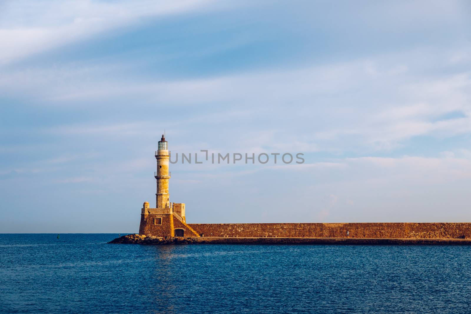 Panorama of venetian harbour waterfront and lighthouse in old harbour of Chania, Crete, Greece. Old venetian lighthouse in Chania, Greece. Lighthouse of the old Venetian port in Chania, Greece.