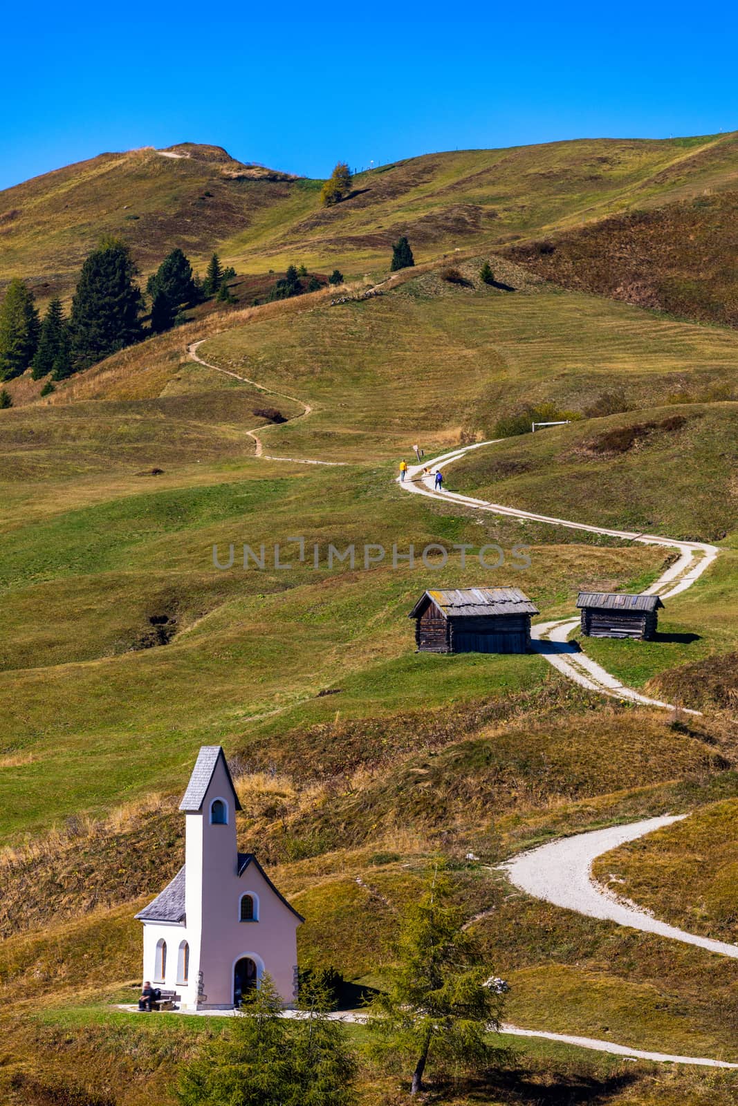 Chapel of San Maurizio at Passo Gardena, South Tyrol, Italy.  View to path to small white chapel San Maurizio and Dolomiti mountain. San Maurizio chapel on the Gardena Pass, South Tyrol, Italy.