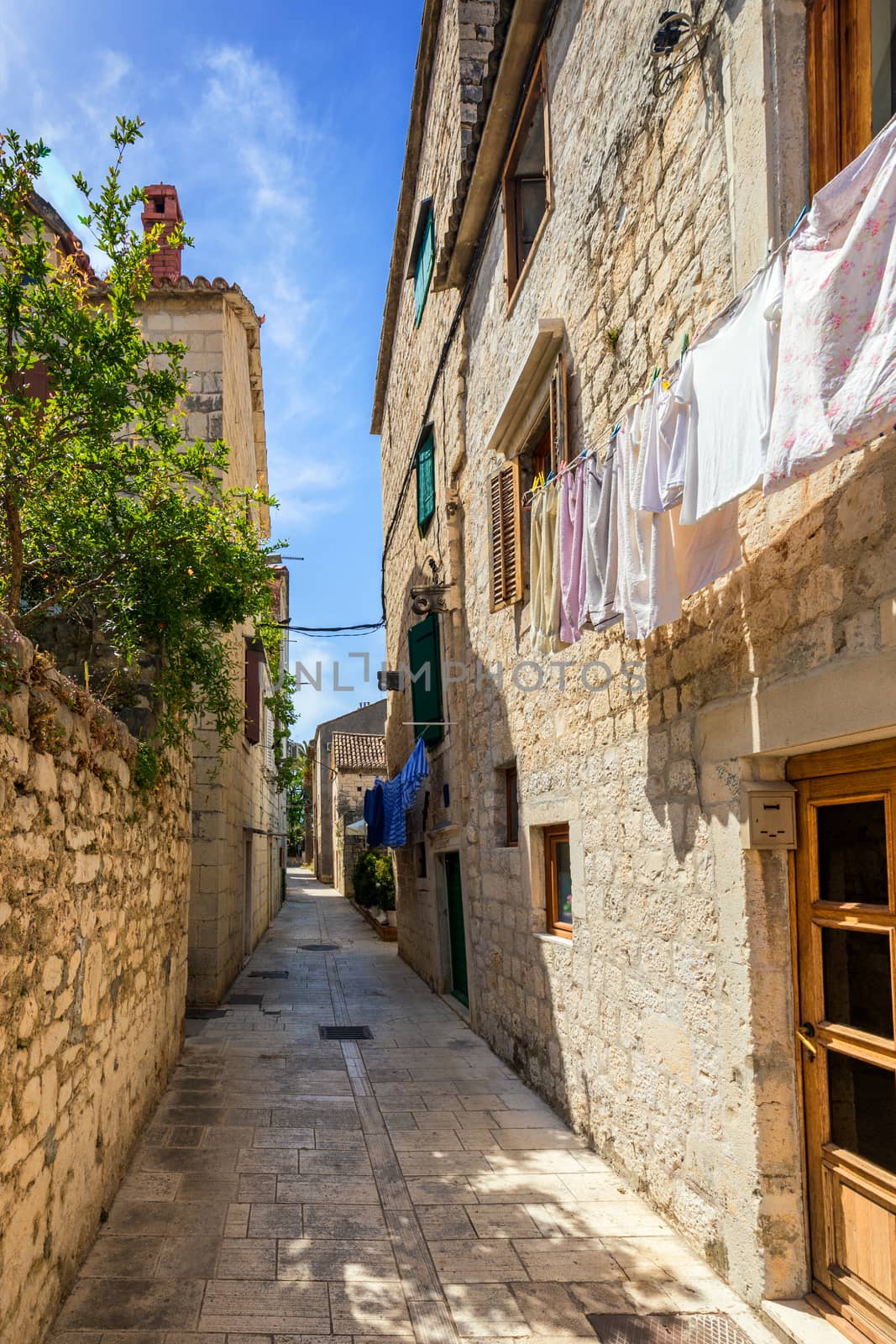 Narrow street in historic town Trogir, Croatia. Travel destination. Narrow old street in Trogir city, Croatia. The alleys of the old town of Trogir are very picturesque and full of charm. Croatia.