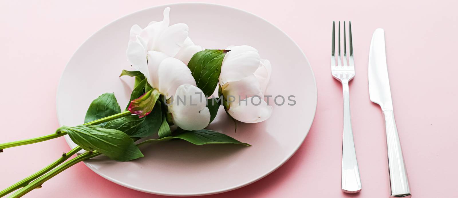 Dining plate and cutlery with peony flowers as wedding decor set on pink background, top tableware for event decoration and menu branding by Anneleven