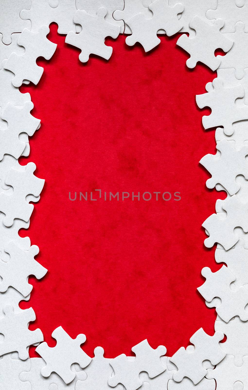 Framing in the form of a rectangle, made of a white jigsaw puzzle. Frame text and jigsaw puzzles. Frame made of jigsaw puzzle pieces on red background.