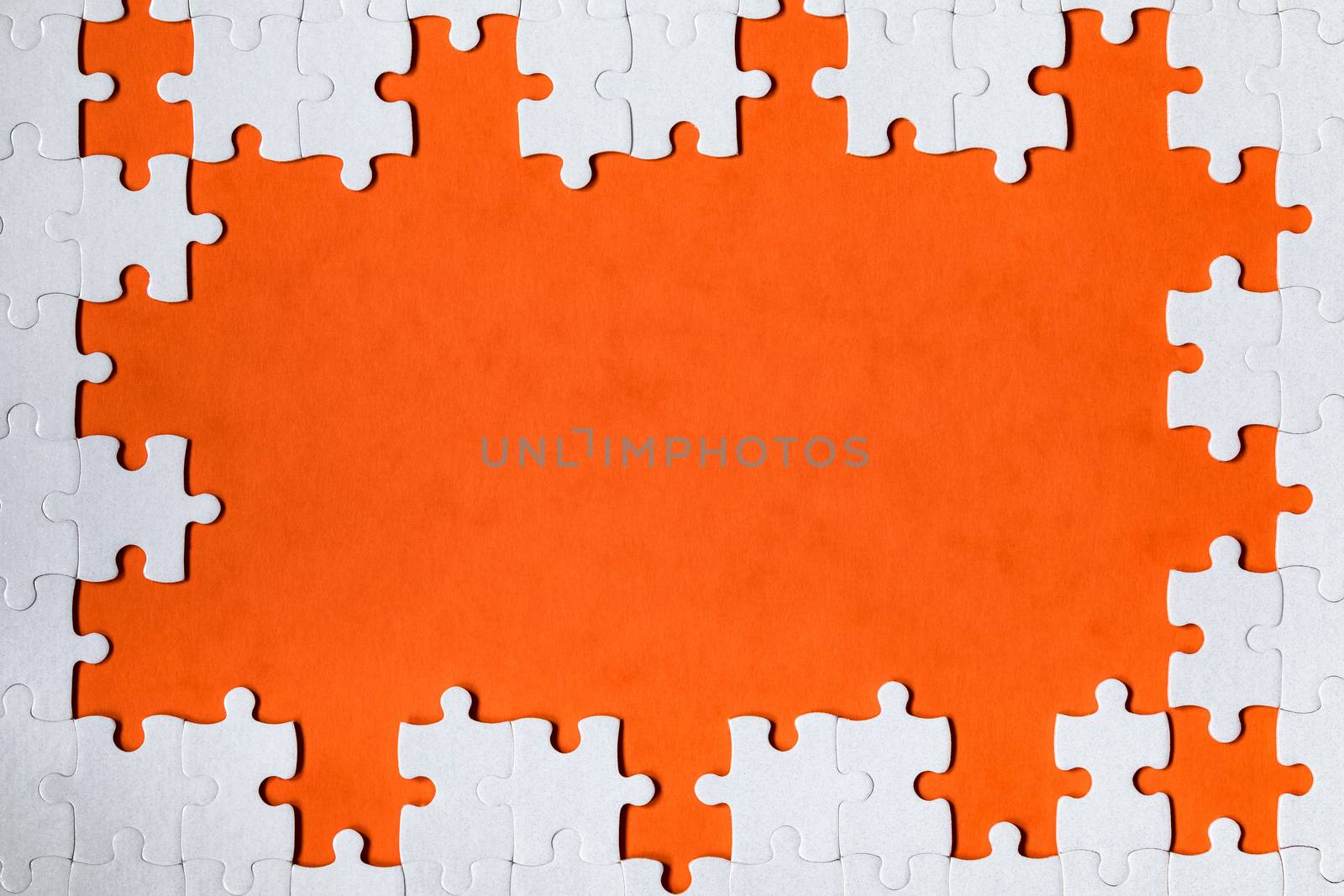 White jigsaw puzzle. White puzzle pieces on color background. Unfinished white jigsaw puzzle pieces on color background. 