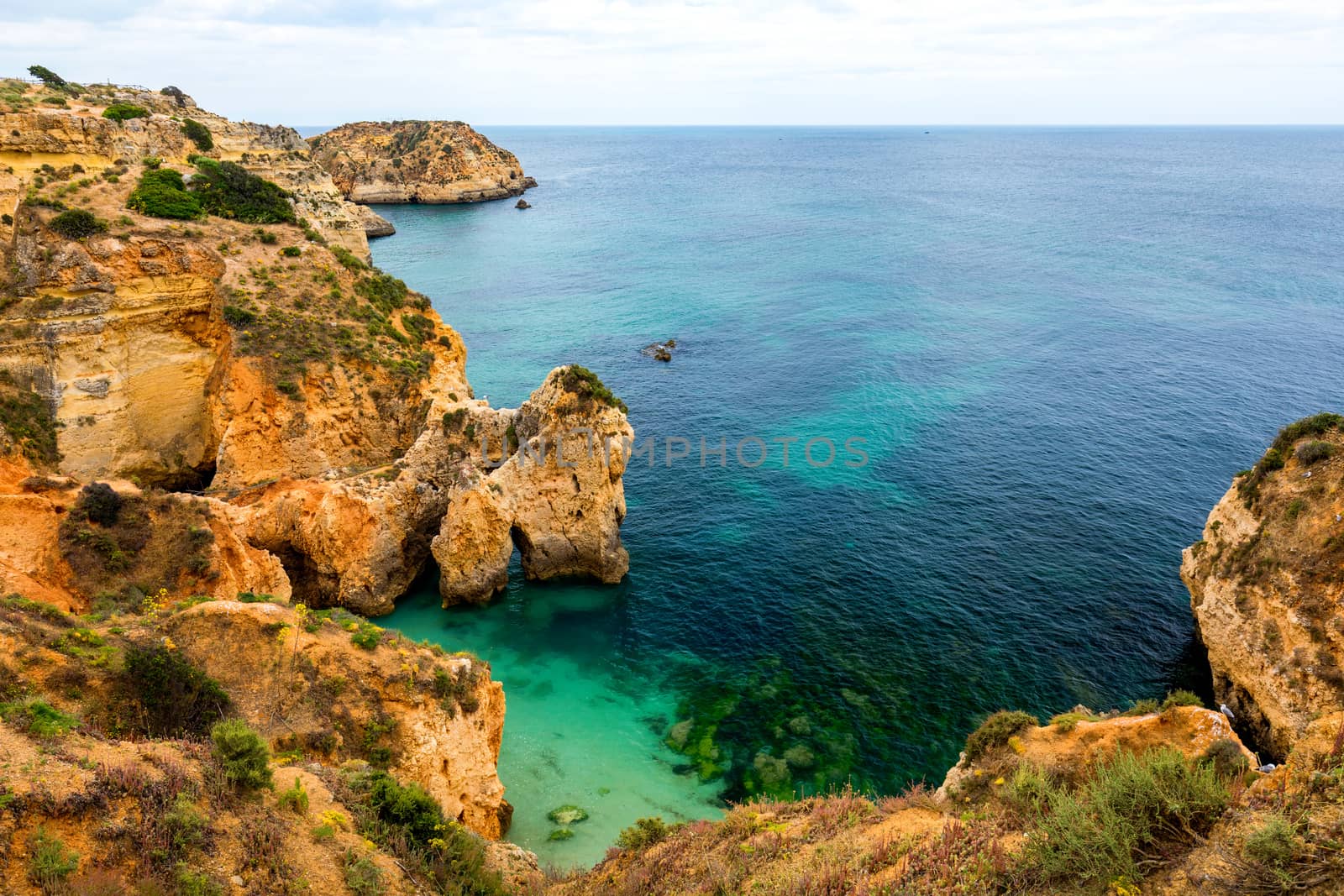 View of stunning beach with golden color rocks in Alvor town , Algarve, Portugal. View of cliff rocks on Alvor beach, Algarve region, Portugal.