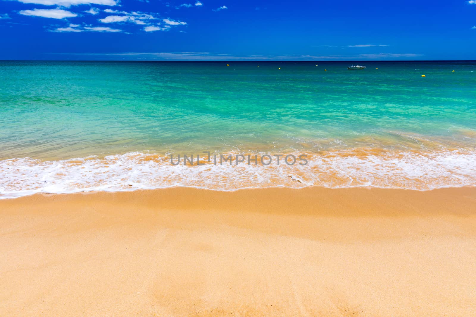 Soft wave of blue ocean on sandy tropical beach. Background of tropical paradise beach with golden sand, travel tourism panorama background concept. Sand and sea waves background.