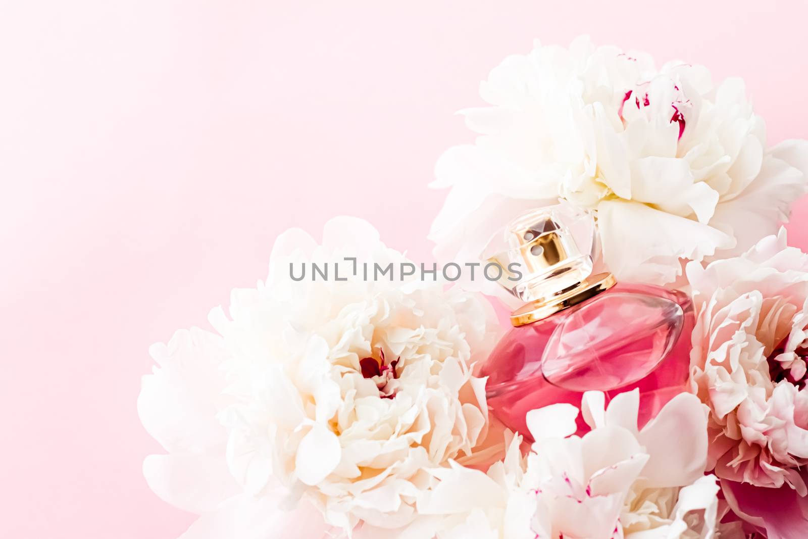 Luxurious fragrance bottle as chic perfume product on background of peony flowers, parfum ad and beauty branding design