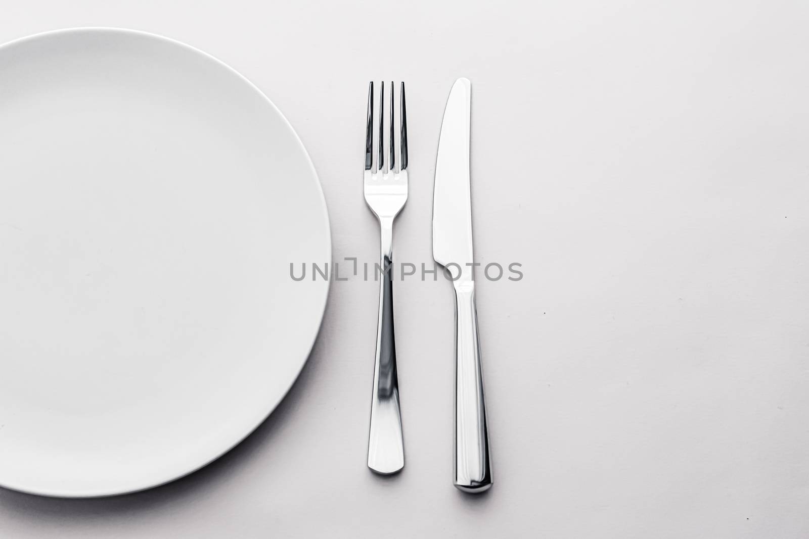 Empty plate and cutlery as mockup set on white background, top tableware for chef table decor and menu branding by Anneleven