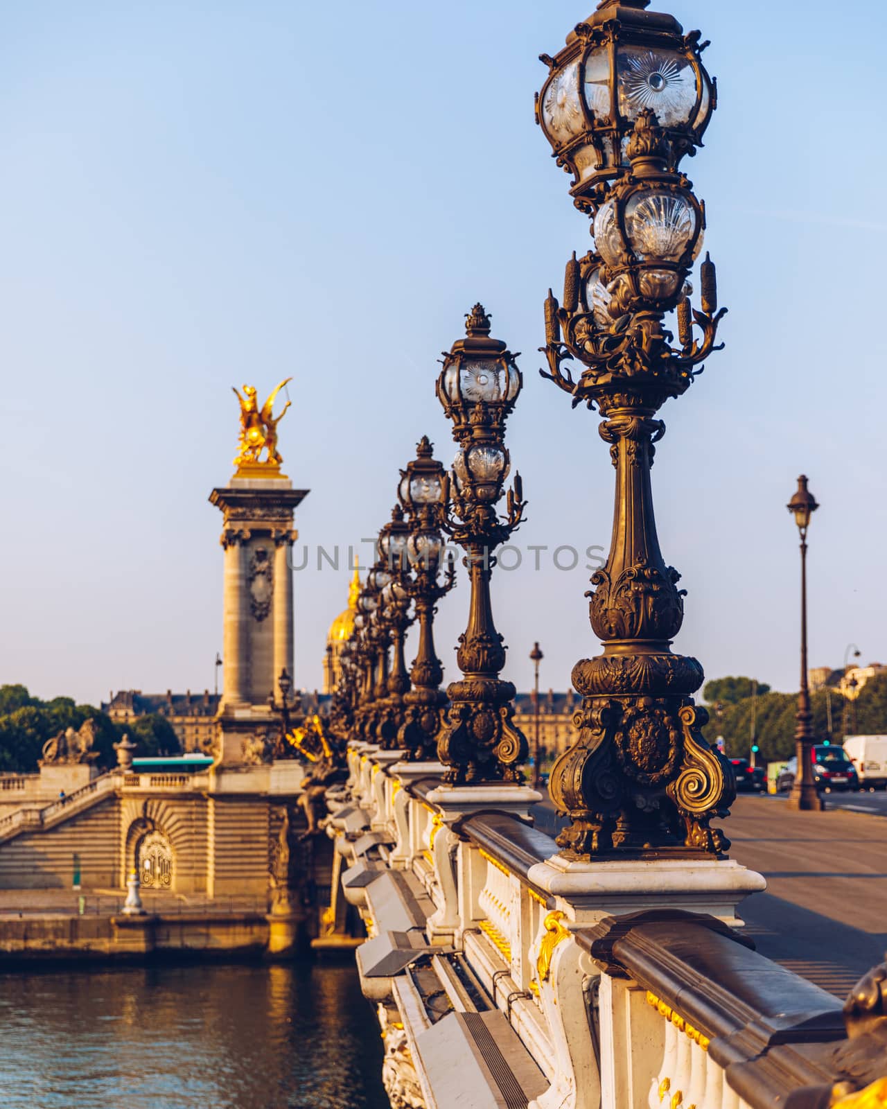 Pont Alexandre III bridge over river Seine in the sunny summer morning. Bridge decorated with ornate Art Nouveau lamps and sculptures. The Alexander III Bridge across Seine river in Paris, France.