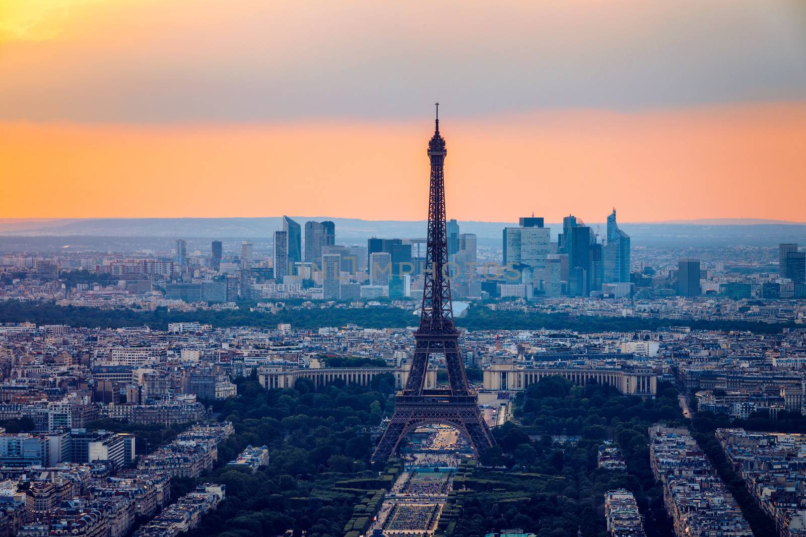 View of Paris with Eiffel Tower from Montparnasse building. Eiffel tower view from Montparnasse at sunset, view of the Eiffel Tower and La Defense district in Paris, France.