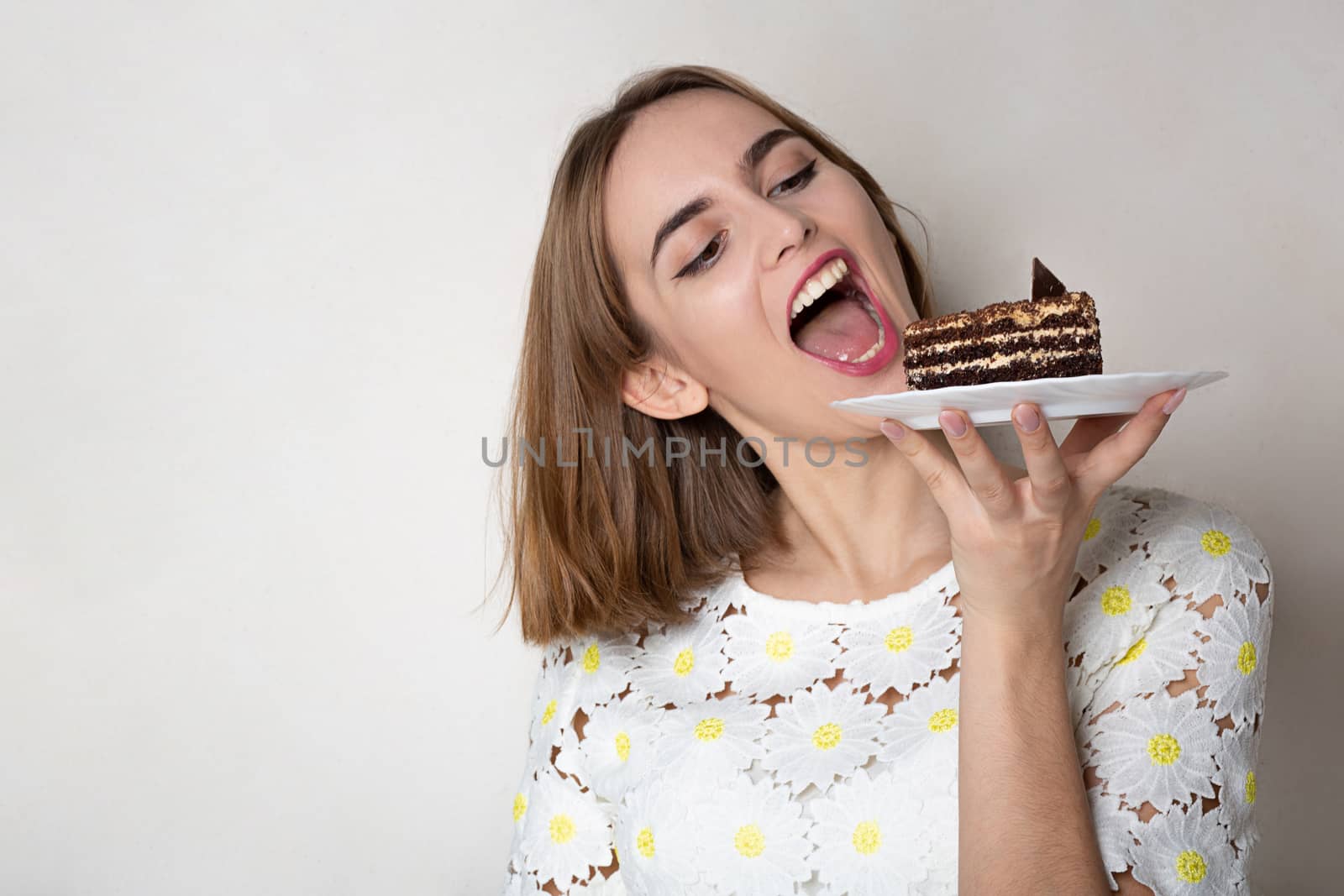 Pleased girl bites yummy cake  by ViktoriiaPav