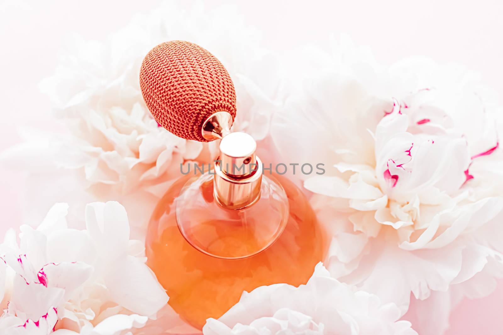 Vintage fragrance bottle as luxe perfume product on background of peony flowers, parfum ad and beauty branding design