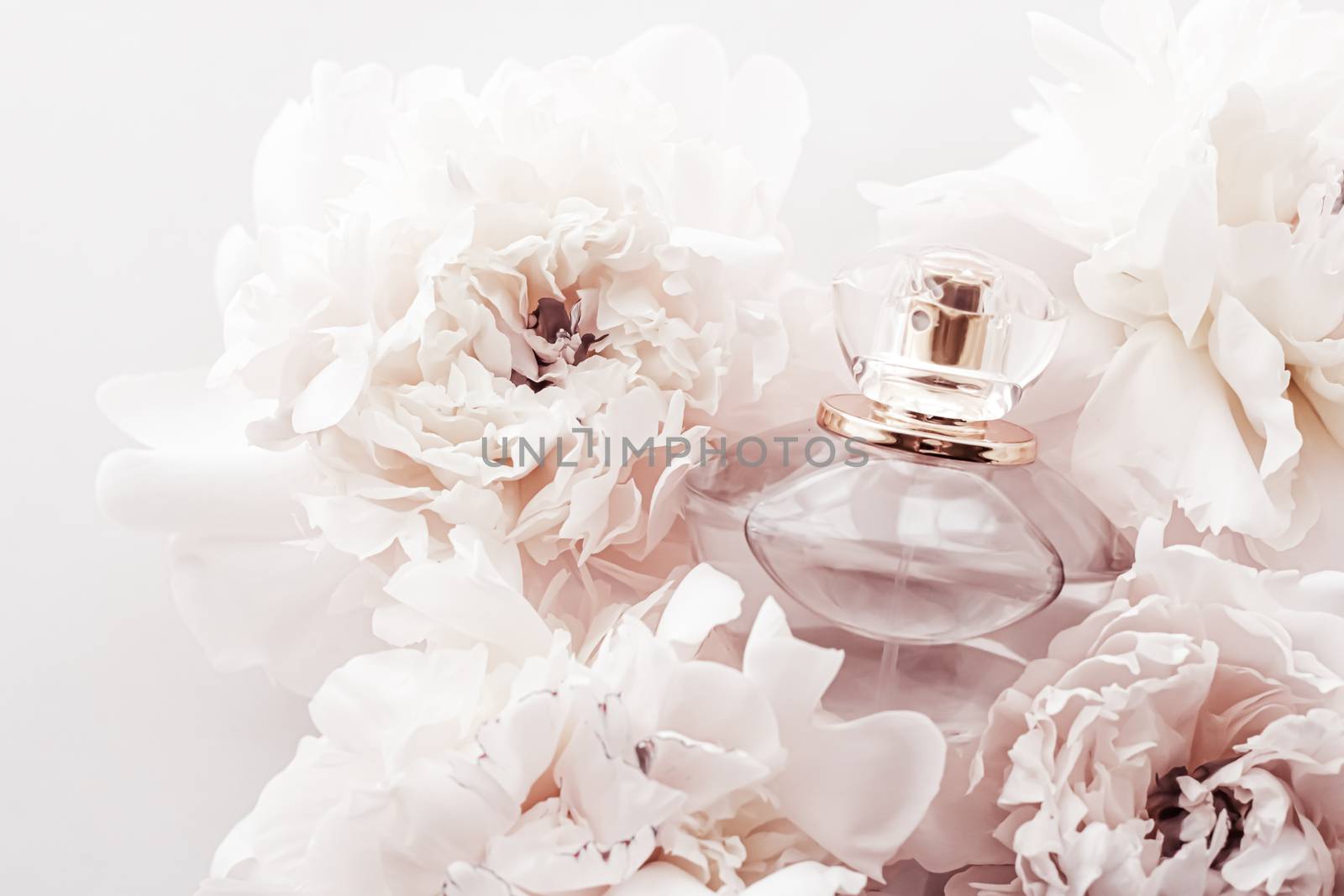 Fragrance bottle as luxury perfume product on background of peony flowers, parfum ad and beauty branding design