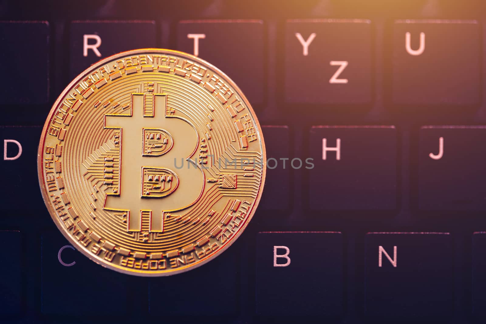 Bitcoin on compuer keyboard in background, symbol of electronic virtual money and mining cryptocurrency concept. Coin crypto currency bitcoin lies on the keyboard. Bitcoin on keyboard.
