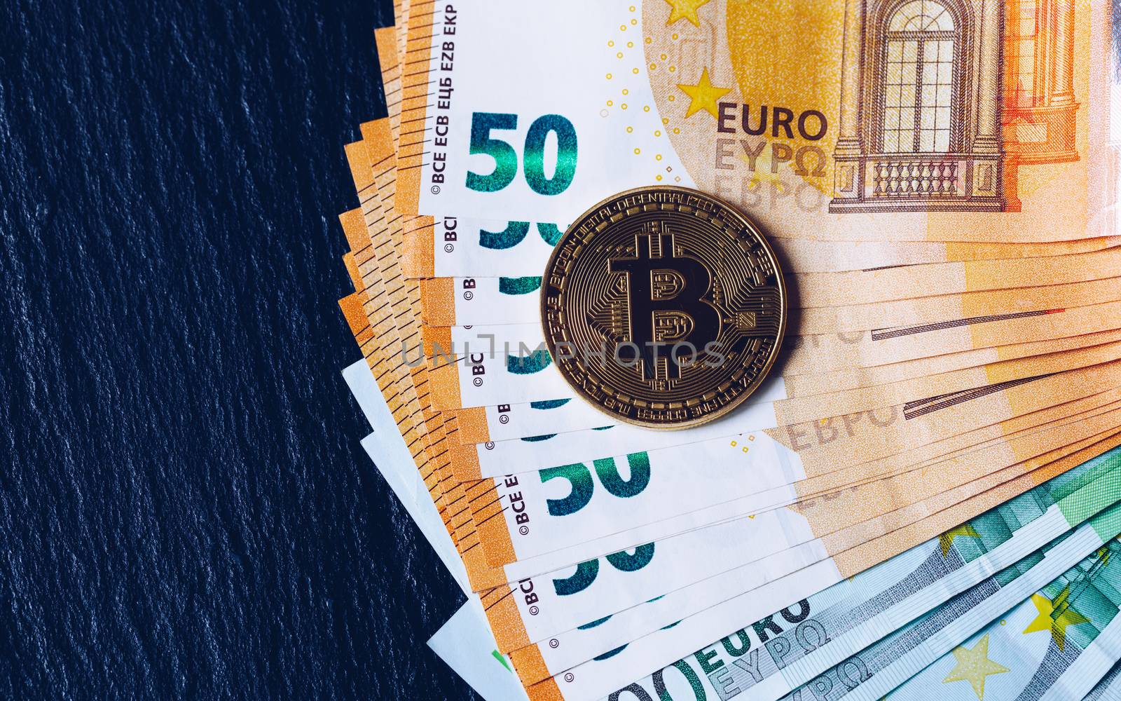 Golden bitcoin over Euro money. Bitcoin cryptocurrency. Crypto currency concept. Bitcoin with euro bills. Bitcoins stacked on euro banknotes.
