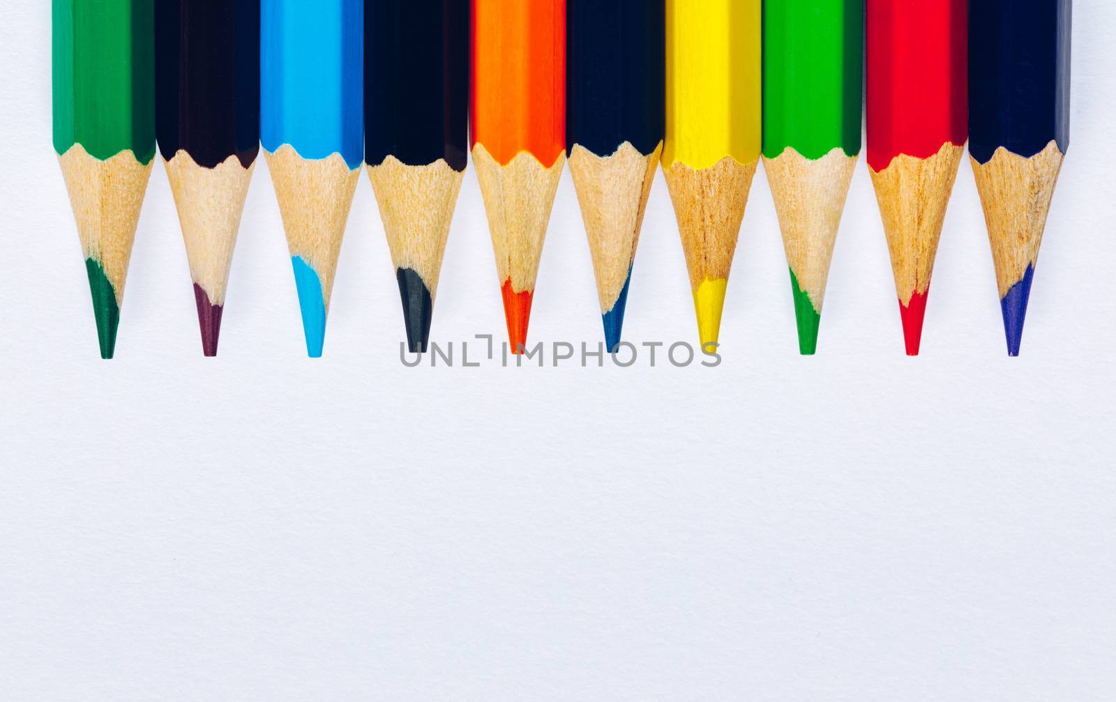 Color pencils isolated on white background. Close up of colored rainbow pencils for drawing, concept of preparing for school and discounts on stationery before the school year.