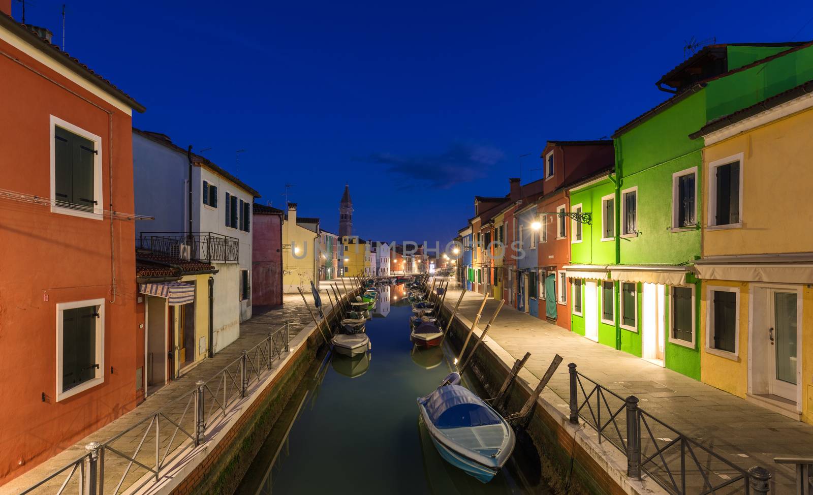 Street view with colorful buildings in Burano island at night, Venice, Italy. Architecture and landmarks of Burano, Venice postcard. Scenic canal and colorful architecture in Burano island near Venice, Italy
