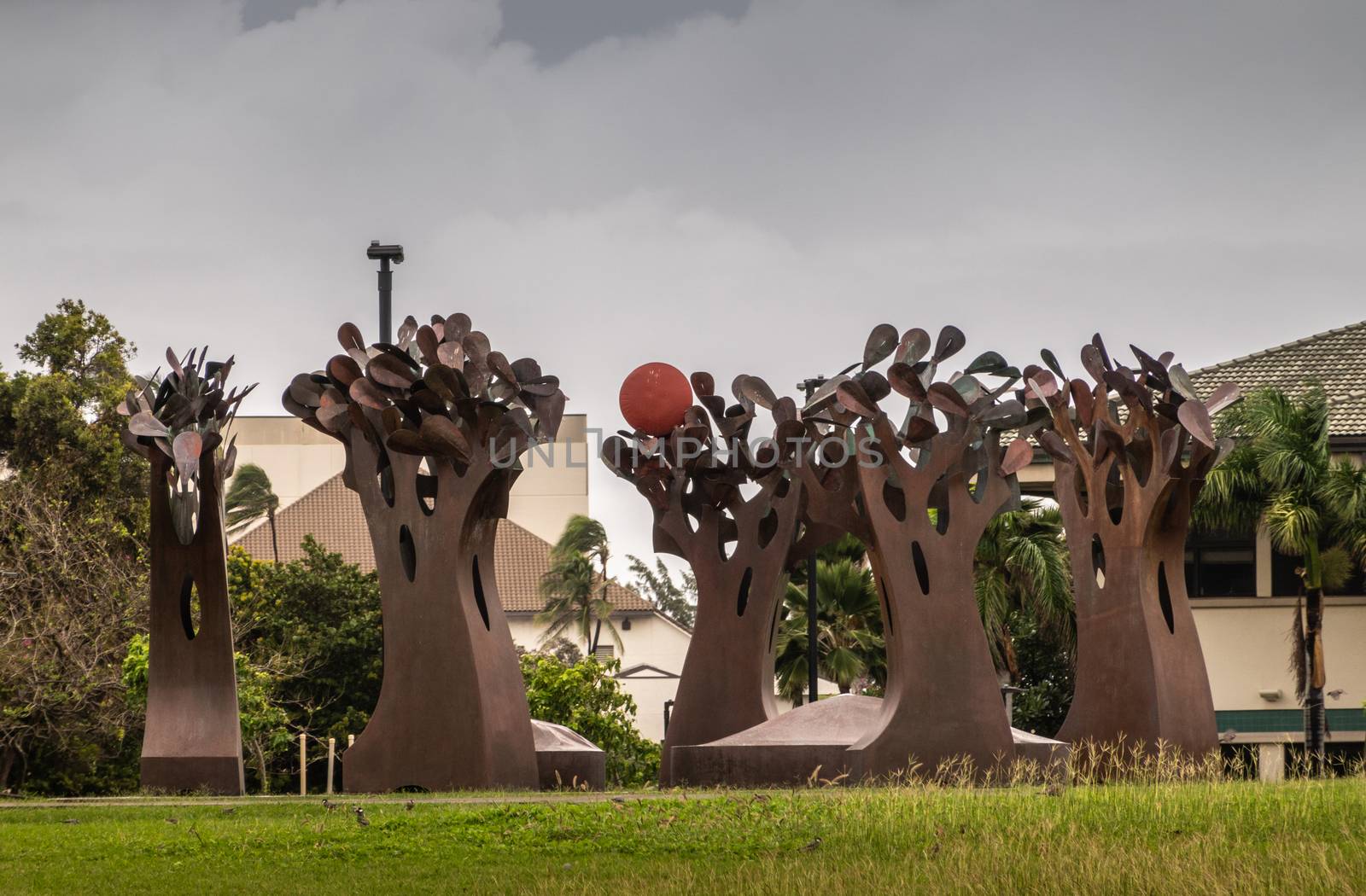 Kahului, Maui,, Hawaii, USA. - January 12, 2020: Brown rusty metal group of trees statue on green lawn at University of Hawaii, Maui college campus. Gray cloudy sky.