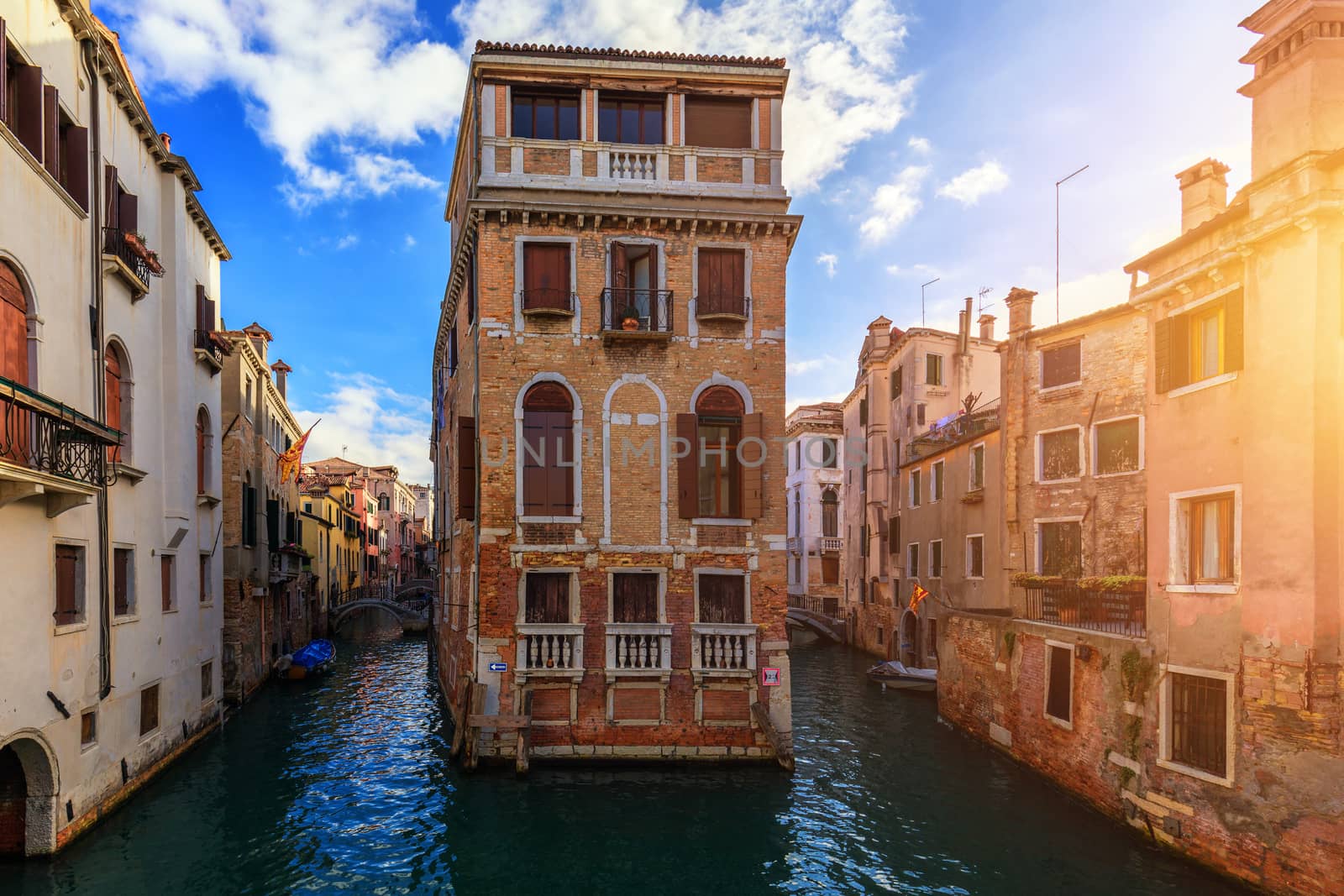 Street canal in Venice, Italy. Narrow canal among old colorful b by DaLiu