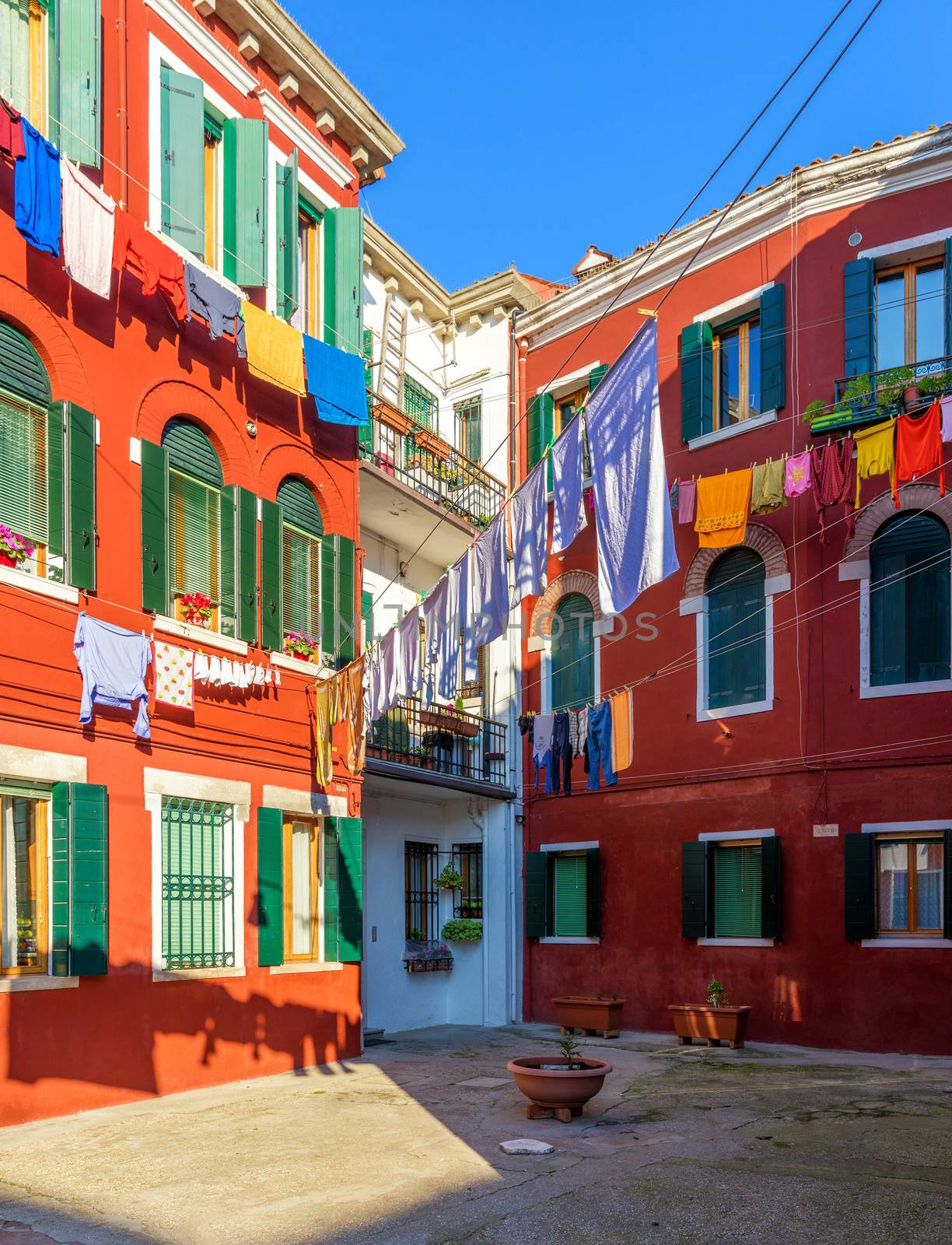 Laundry hanging out of typical houses of Burano Island, Venice,  by DaLiu