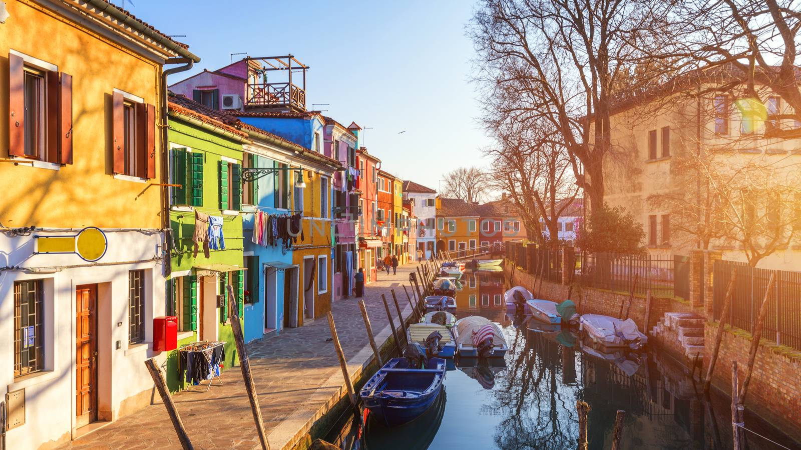 Street with colorful buildings in Burano island, Venice, Italy. Architecture and landmarks of Burano, Venice postcard. Scenic canal and colorful architecture in Burano island near Venice, Italy