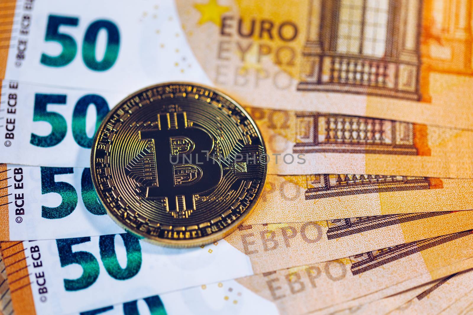 Golden bitcoin over Euro money. Bitcoin cryptocurrency. Crypto currency concept. Bitcoin with euro bills. Bitcoins stacked on euro banknotes.