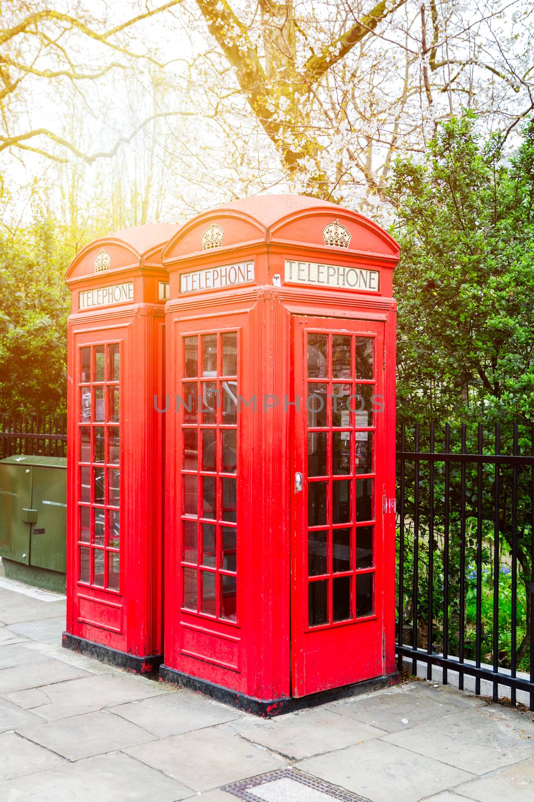 Red telephone box in street with historical architecture in Lond by DaLiu