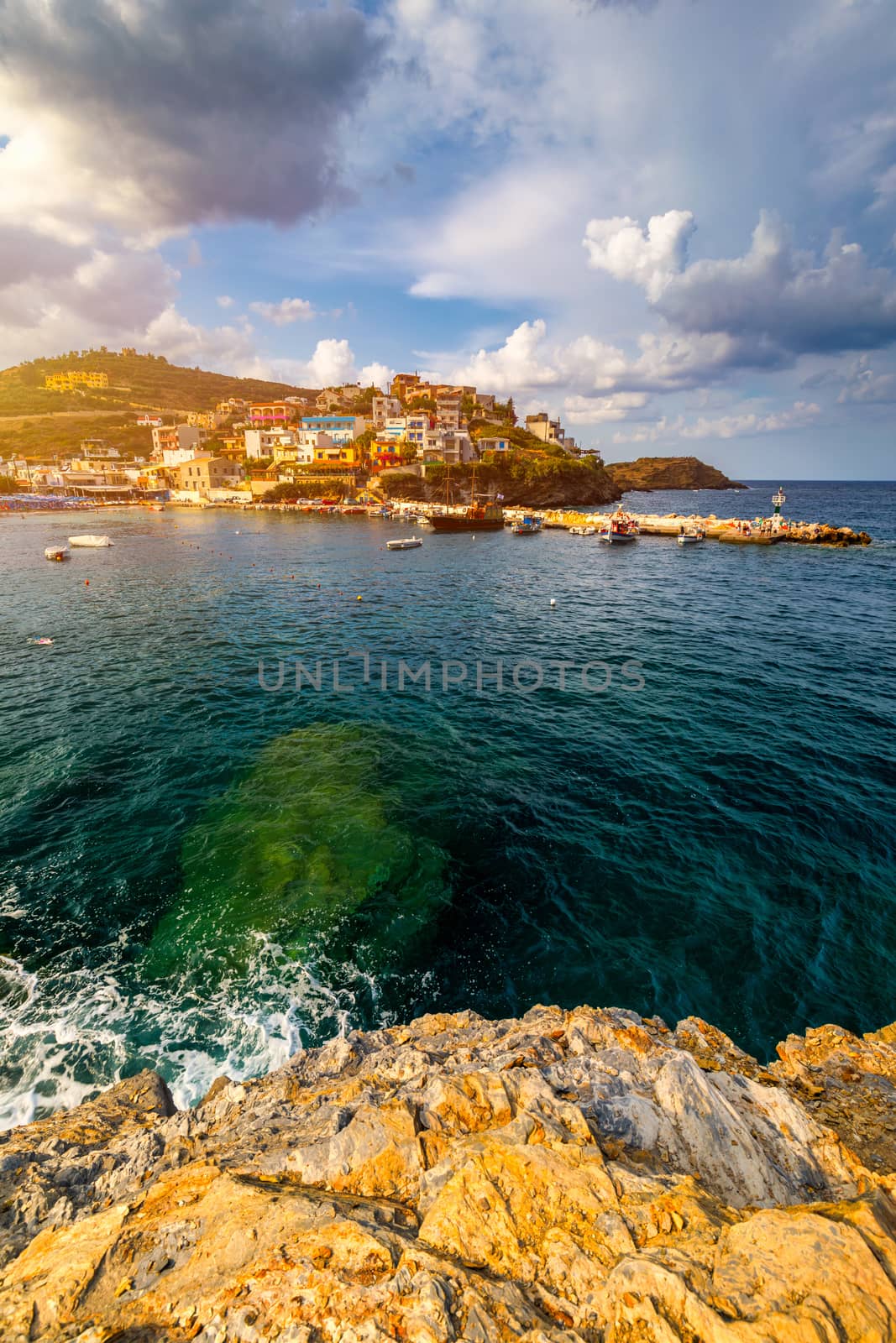 Panorama of Harbour with vessels, boats, beach and lighthouse in Bali at sunrise, Rethymno, Crete, Greece. Famous summer resort in Bali village, near Rethimno, Crete, Greece. 