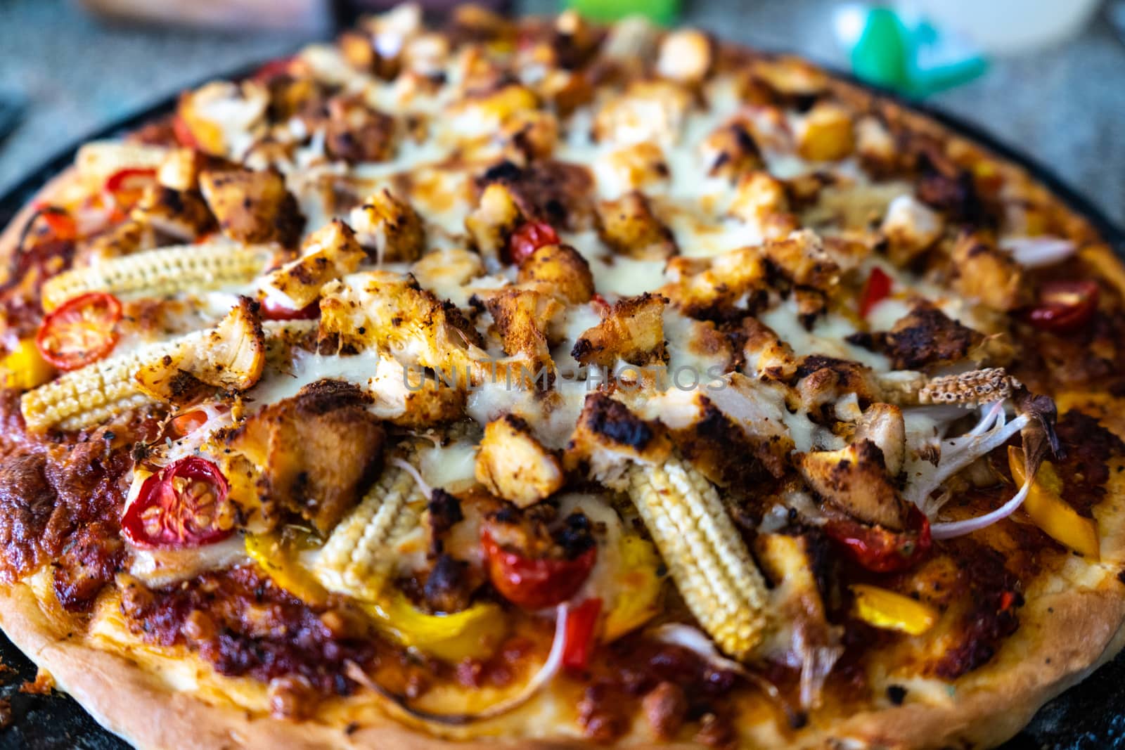 Top view of home made pizza with sauce, vegetables, baby corn, corn, tomatoes, mushrooms and more . Shows the various cooking experiments during the pandemic lockdown