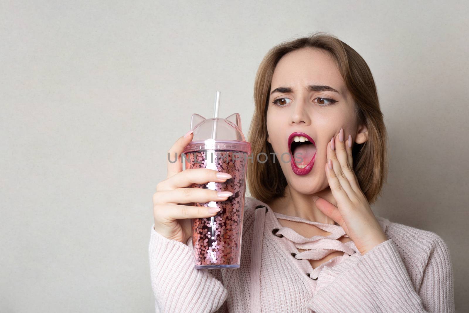 Surprised girl holding glass of juice  by ViktoriiaPav