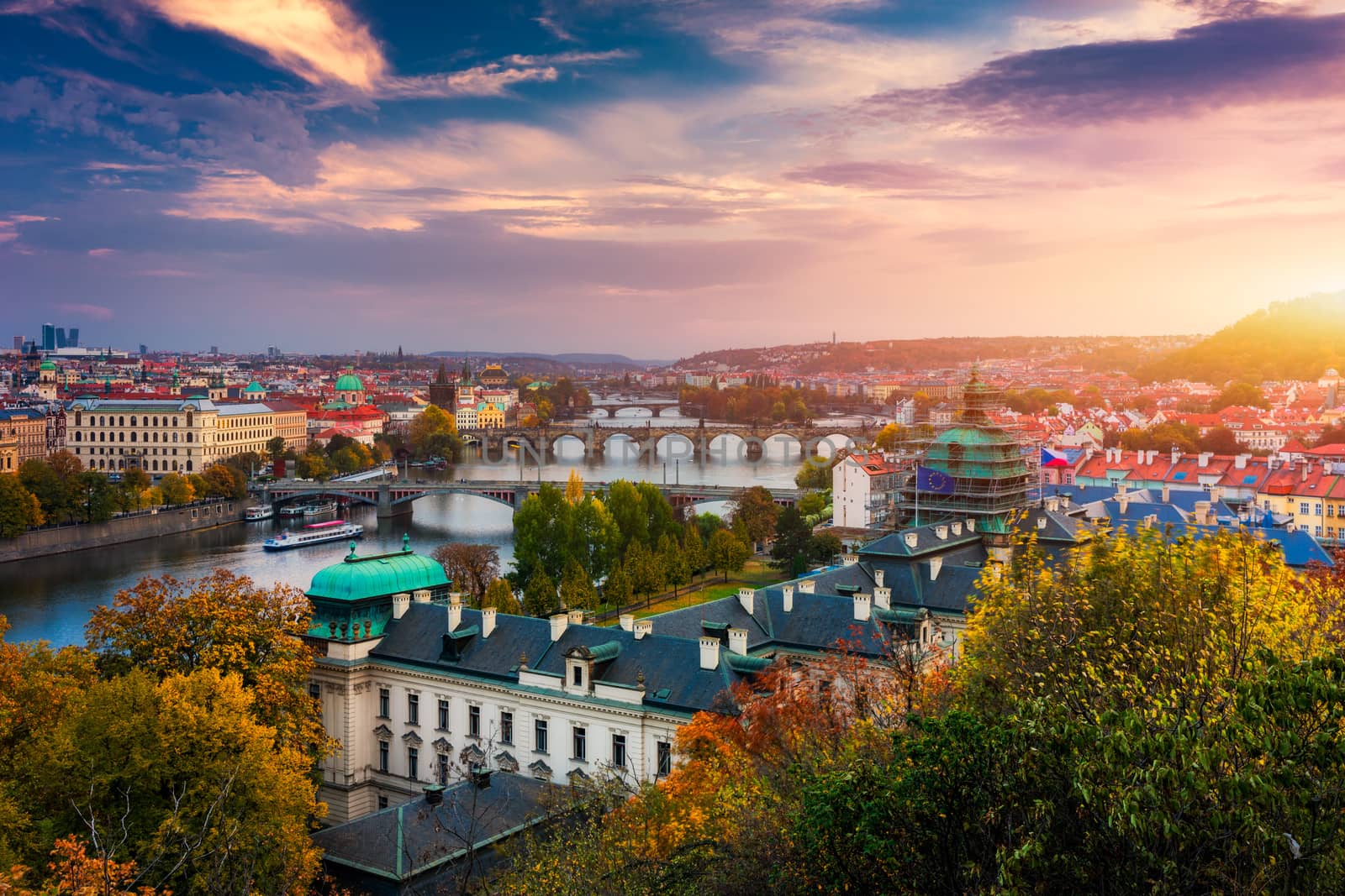 Autumn view to Charles bridge on Vltava river in Prague, Czech Republic. Autumn view to Charles Bridge, Prague old town and Vltava river from Letna park (Letenske sady) at sunset with colorful sky.